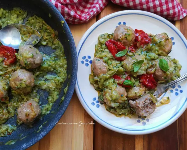 Polpette di zucchine in padella, gustose e leggere, servite con pomodorini e basilico fresco.