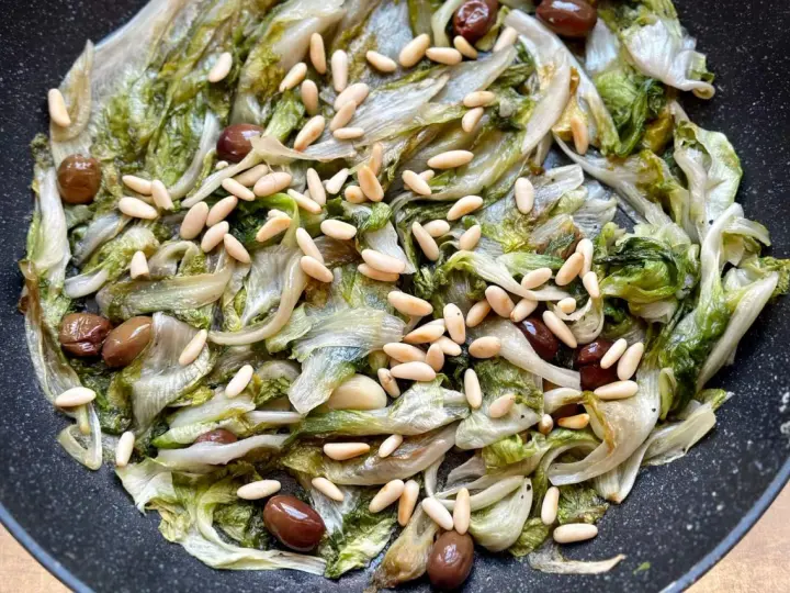 Scarola in padella con olive e pinoli, un contorno saporito e leggero.