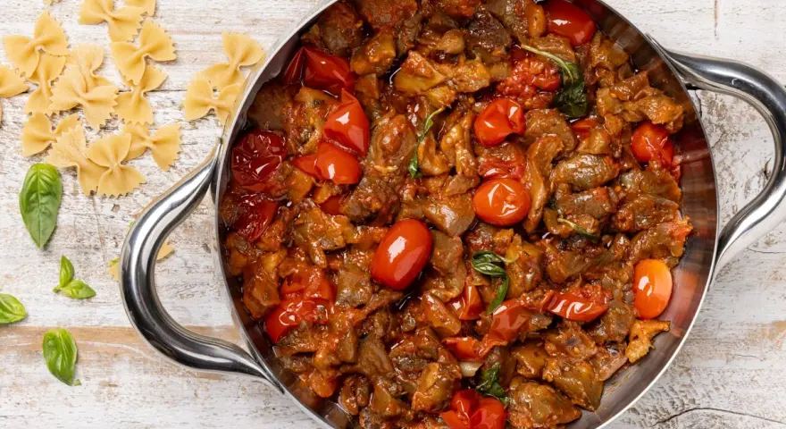 Sugo con melanzane e pomodorini in padella, pronto per condire la pasta.