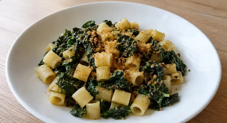 Piatto di pasta con cavolo nero e acciughe, condita con pangrattato croccante.