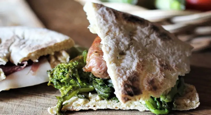 Torta al testo ripiena di salsiccia e verdure, un sapore autentico.
