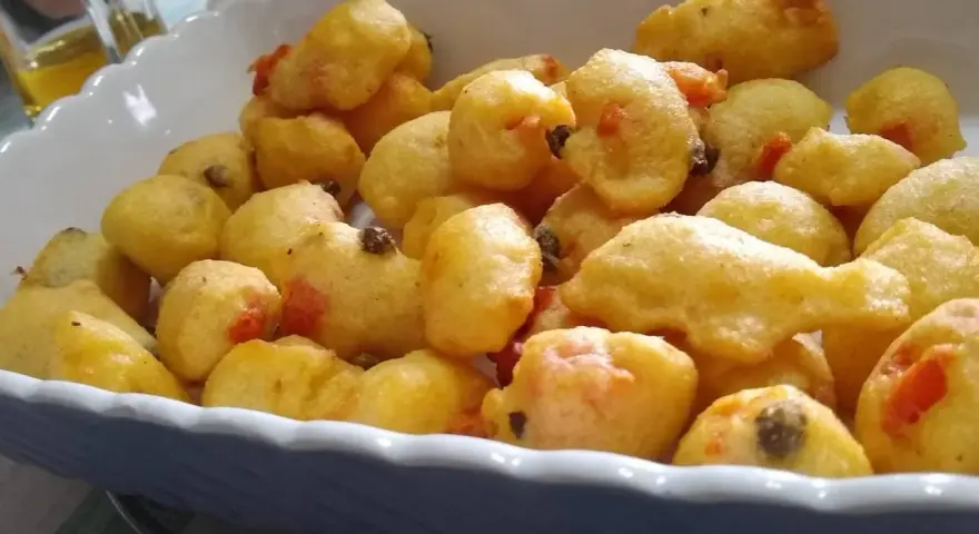 Pittule salentine dorate e fragranti, un tripudio di sapori pugliesi in un piatto.