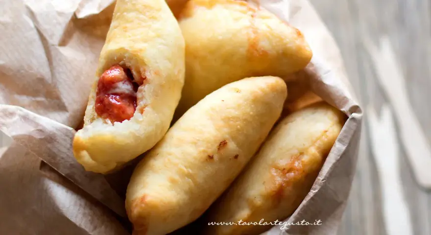 Panzerotti pugliesi dorati e fragranti, uno aperto rivela un ripieno succulento.