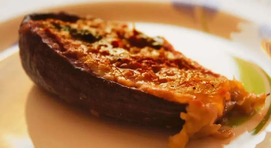 Melanzane ripiene calabresi, un piatto saporito con un ripieno dorato e filante, pronto per essere gustato.