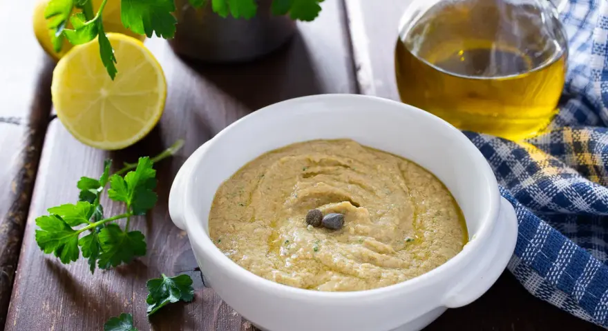 Una cremosa salsa tonnata con uova sode, guarnita con capperi, pronta per essere gustata.