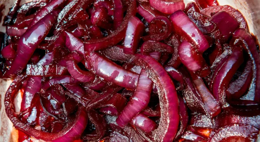 Cipolla rossa caramellata, lucida e succosa, pronta per arricchire ogni piatto con il suo sapore dolce e intenso.