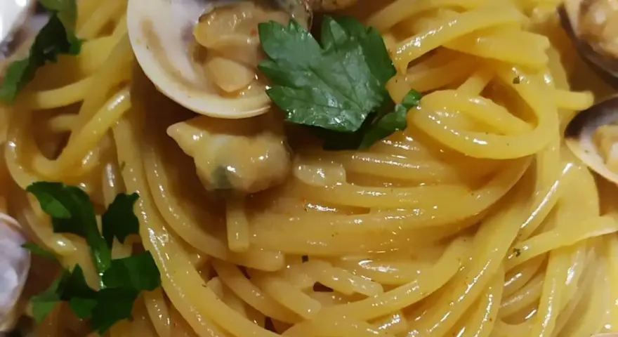 Spaghetti alle vongole cremosi come al ristorante, un piatto invitante con vongole fresche e prezzemolo.