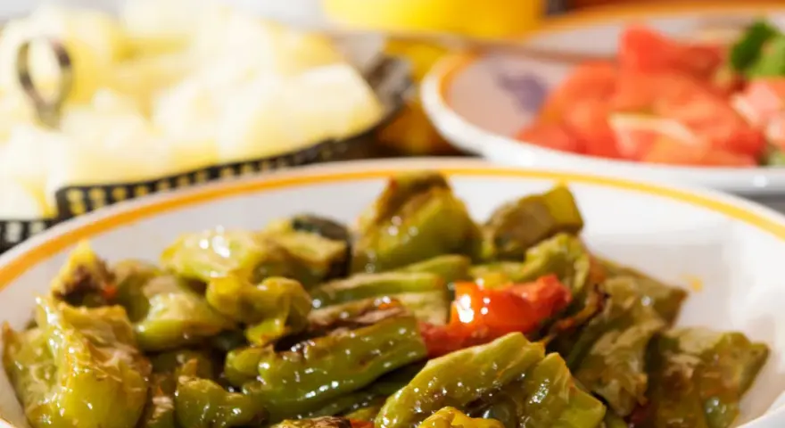 Un piatto di peperonata ricetta della nonna, con peperoni verdi e qualche pomodoro, cotta lentamente per un sapore autentico.