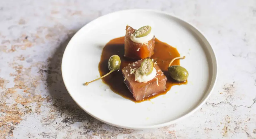 Cubetti di tonno vitellato con salsa bruna, capperi e una quenelle di maionese.
