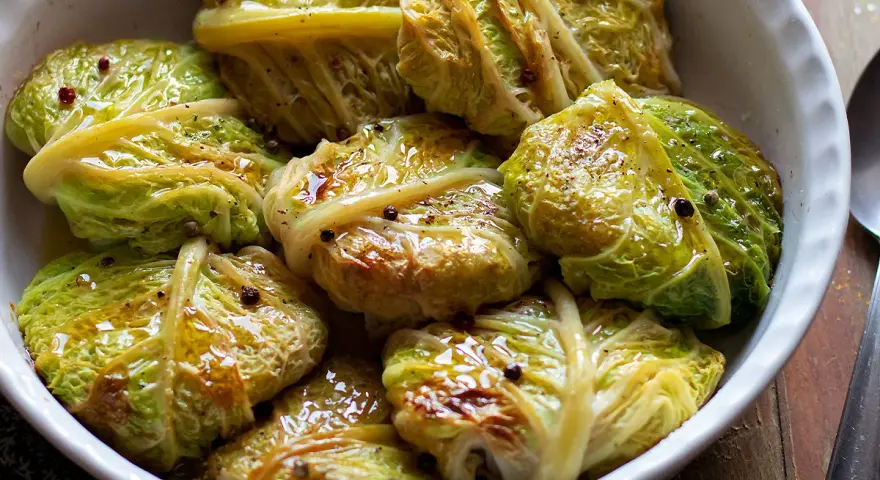 Verza ripiena in teglia, condita con olio e pepe nero. Un piatto confortante e saporito, pronto per essere gustato.