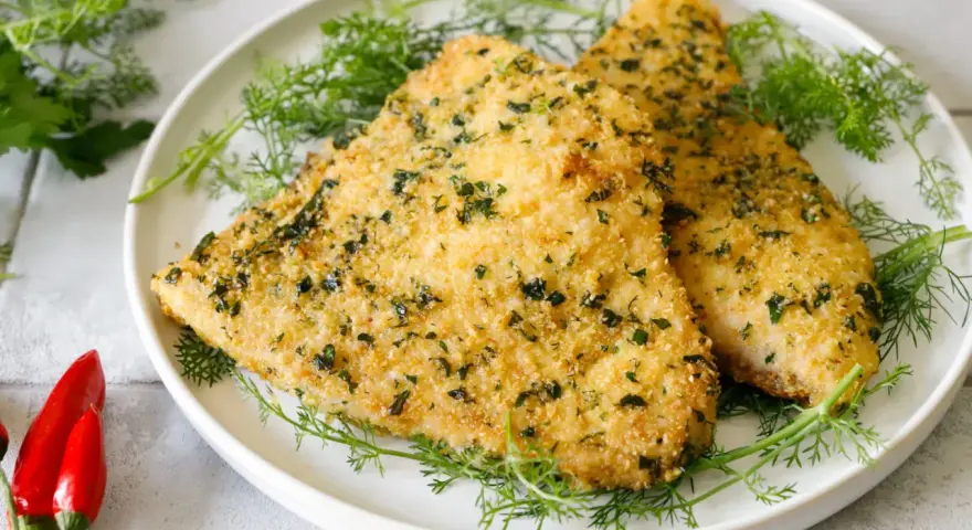 Due filetti dorati di pesce spada alla palermitana, croccanti e profumati, adagiati su un letto di finocchietto fresco.