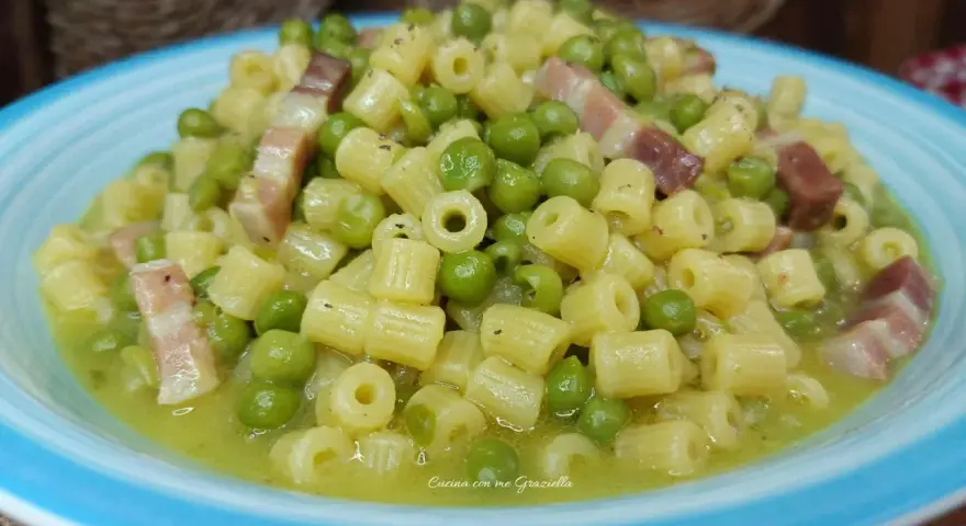 Un piatto invitante di pasta e piselli con cubetti di pancetta croccante, condito con una salsa cremosa.