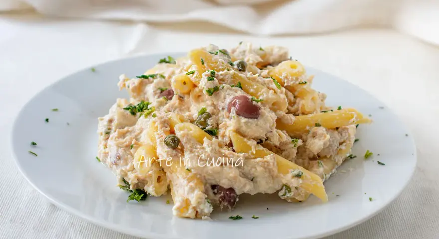 Piatto di pasta cremosa con tonno, olive nere e capperi, guarnita con prezzemolo fresco. Un classico della pasta tonno e olive.