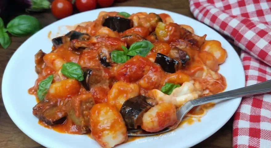Gnocchi all'ortolana con melanzane, pomodorini e basilico fresco, un piatto colorato e saporito.