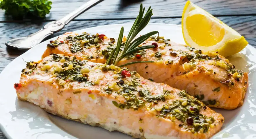 Delizioso salmone al forno con erbe aromatiche, aglio e un tocco di limone, pronto per essere gustato.