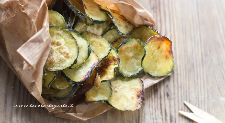 Delizioso contorno di zucchine fritte, croccanti e dorate, servite in un sacchetto di carta.