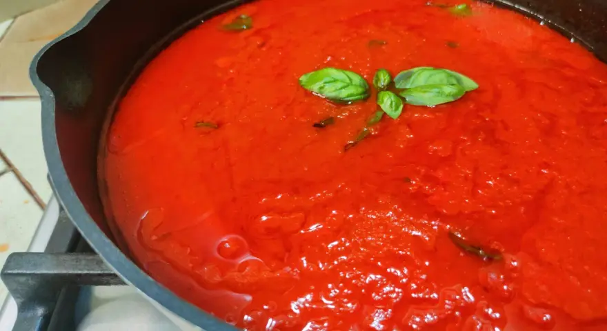 Sugo di pomodoro fresco in padella, profumato con basilico. La ricetta della nonna per un sapore autentico.
