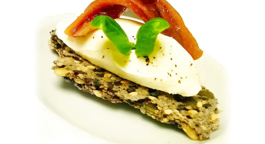 Crostini con burrata cremosa, alici del Cantabrico e basilico fresco. Un boccone di puro piacere.