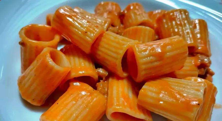 Un primo piatto invitante: rigatoni conditi con un sugo rosso cremoso, un'autentica pasta alla carcerata.