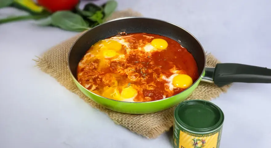 Uova in padella con sugo di pomodoro, un'idea per una frico ricetta veloce e gustosa.