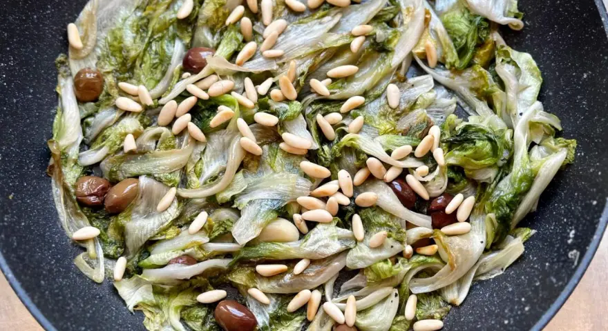 Scarola in padella con olive e pinoli, un contorno saporito e leggero.