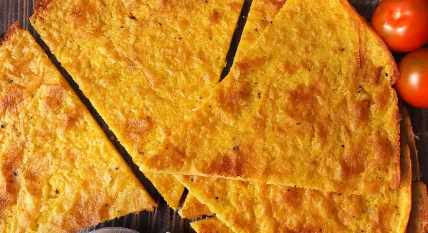 Fetta di cecina dorata, croccante e profumata, pronta per essere gustata. Una deliziosa cecina ricetta da provare subito!