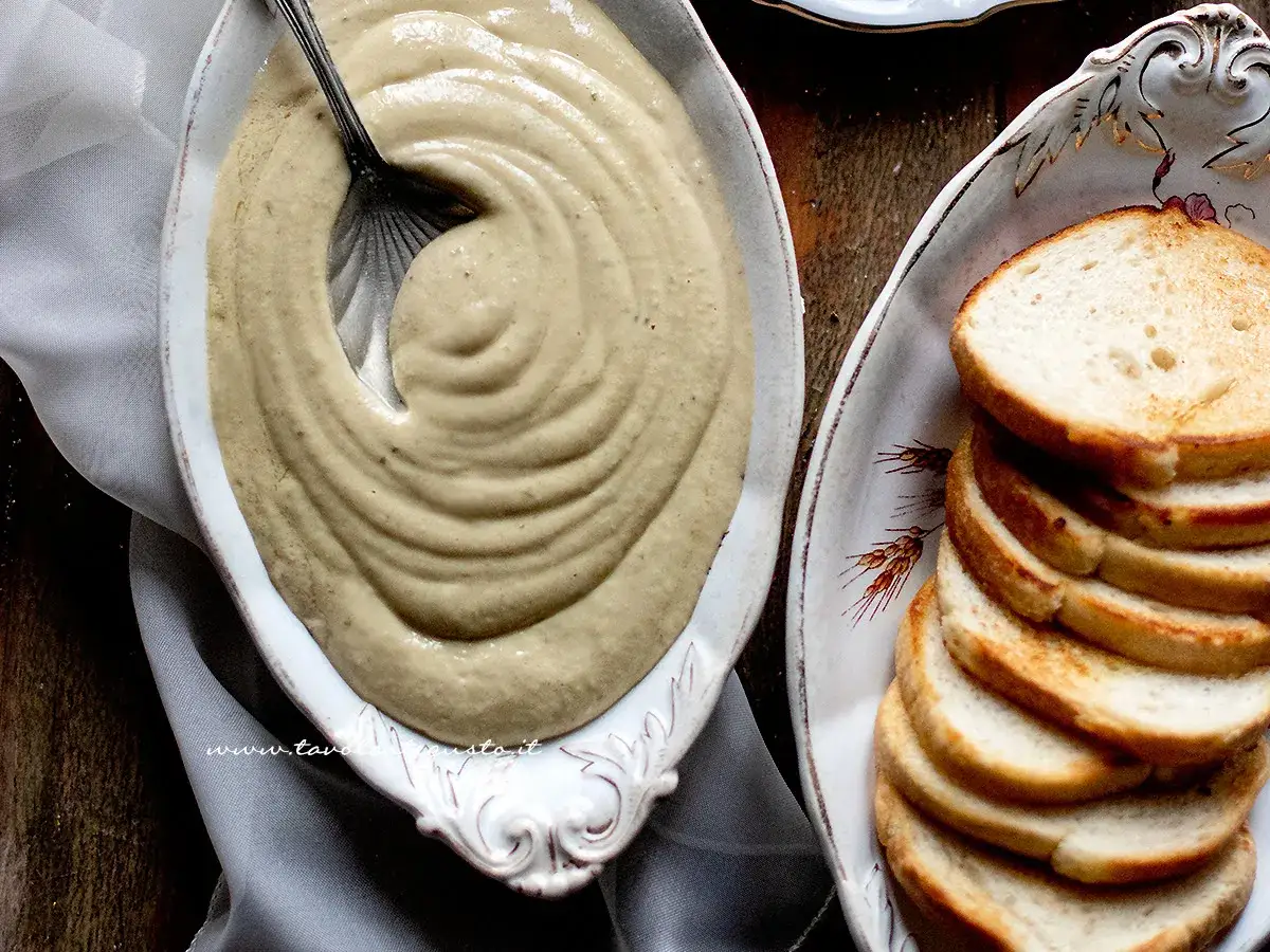 Salsa tonnata con maionese cremosa in un piatto, servita con fette di pane tostato.