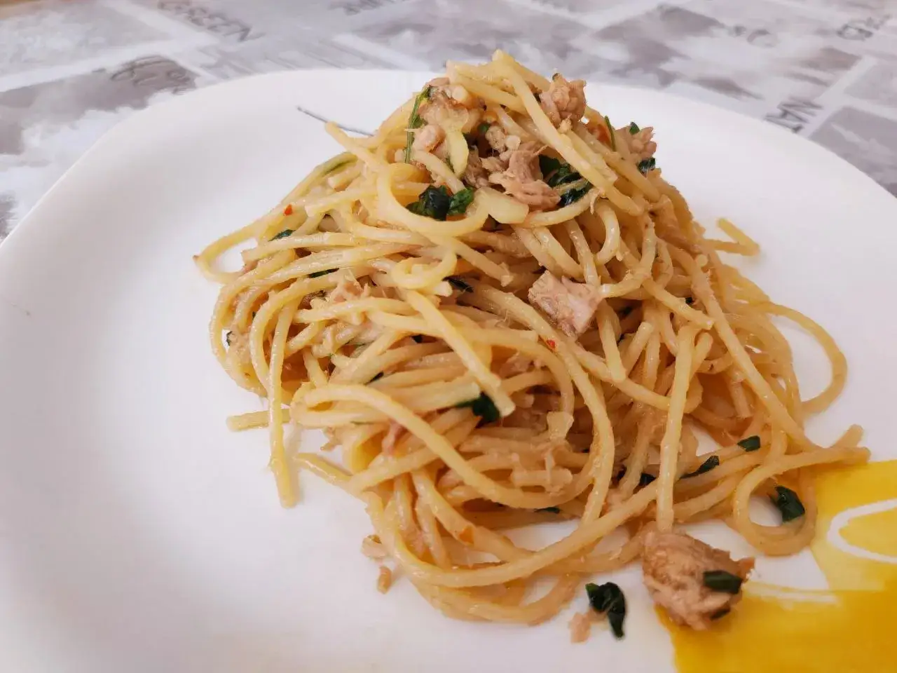 Spaghetti al tonno, la ricetta della nonna che profuma di mare e basilico fresco. Un piatto semplice e gustoso.