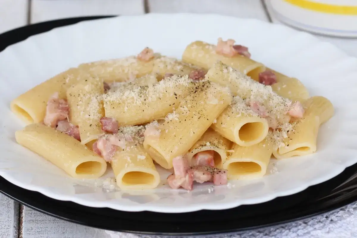 Un piatto di pasta alla gricia fumante, con guanciale croccante, pecorino romano e pepe nero.