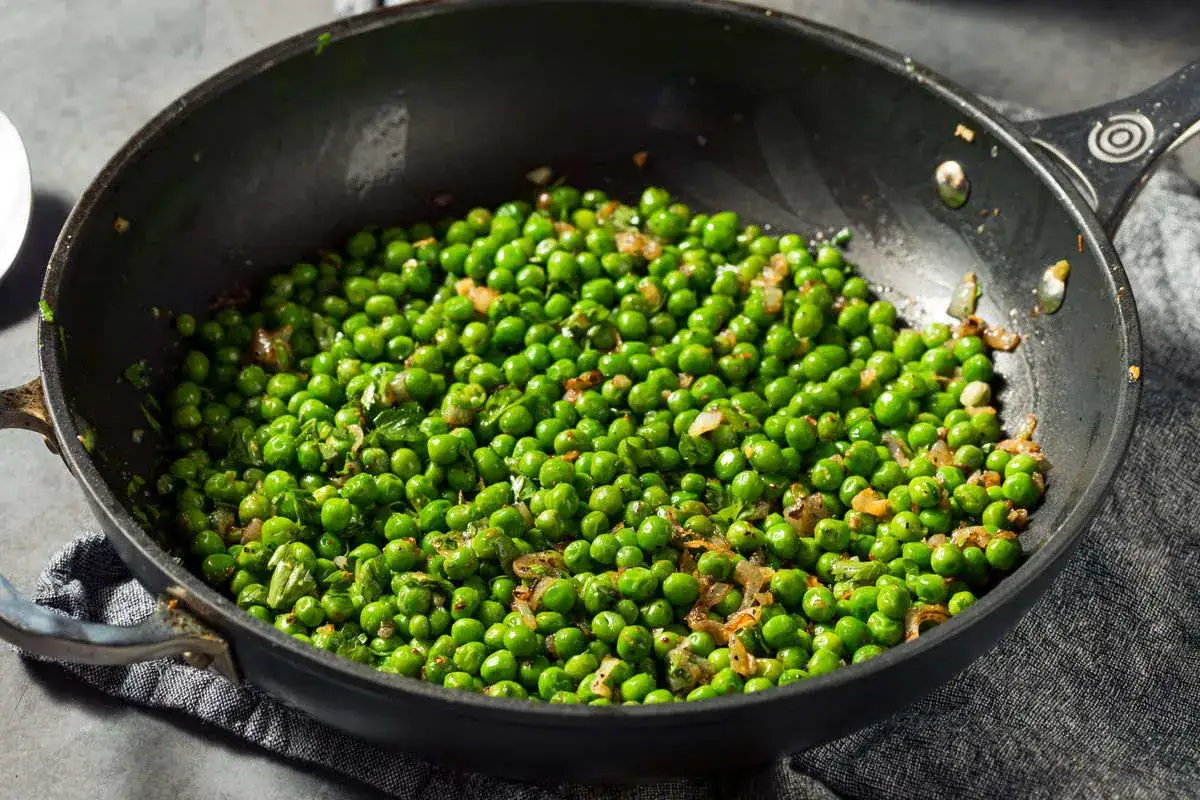 Piselli freschi saltati in padella con cipolla e erbe aromatiche, un contorno semplice e gustoso.