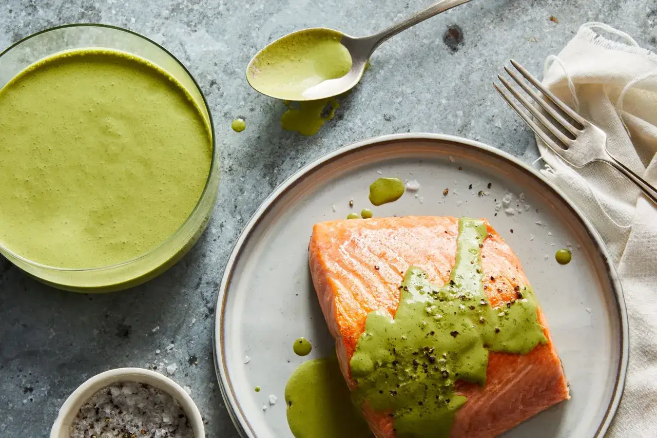 Salmone succulento con una cremosa salsa con yogurt greco, guarnita con pepe nero e sale grosso.