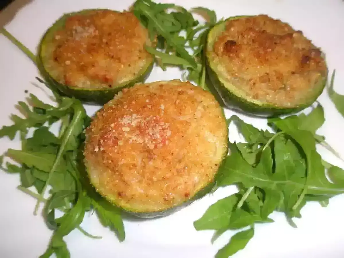 Tre zucchine tonde ripiene, dorate al forno e servite su un letto di rucola fresca. Un piatto gustoso e leggero.