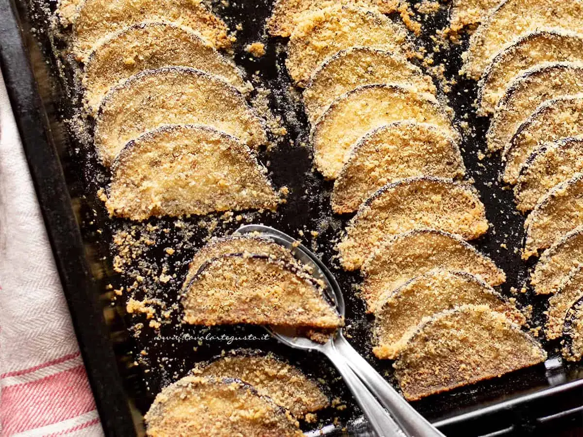 Fette di melanzane impanate al forno, dorate e croccanti, pronte per essere gustate.