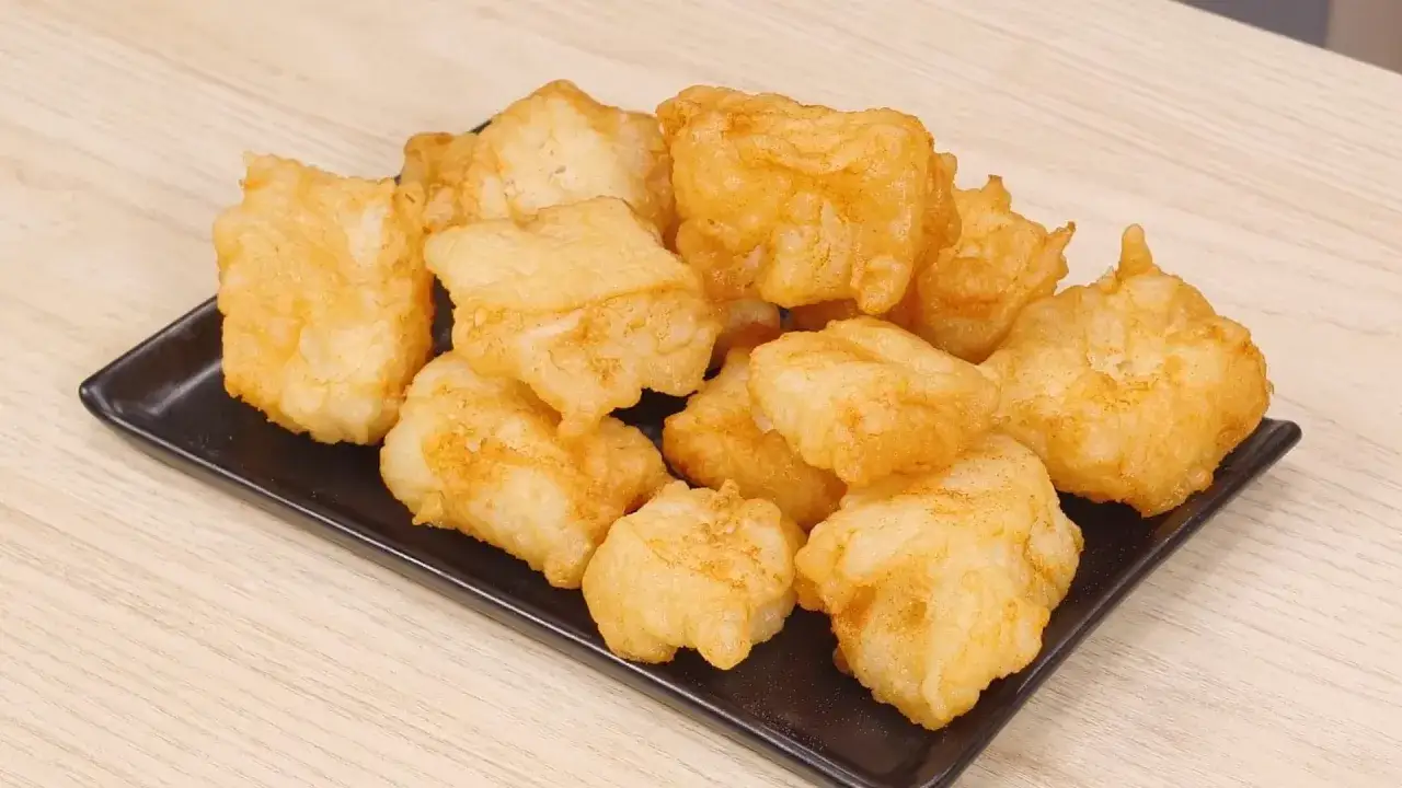 Un piatto di invitante baccal&agrave; fritto, dorato e croccante, pronto per essere gustato.