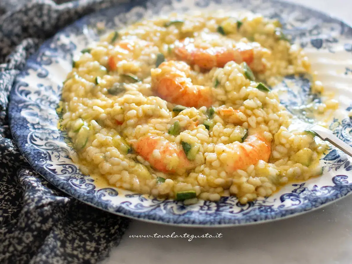 Un cremoso risotto zucchine e gamberetti, servito su un piatto decorato.