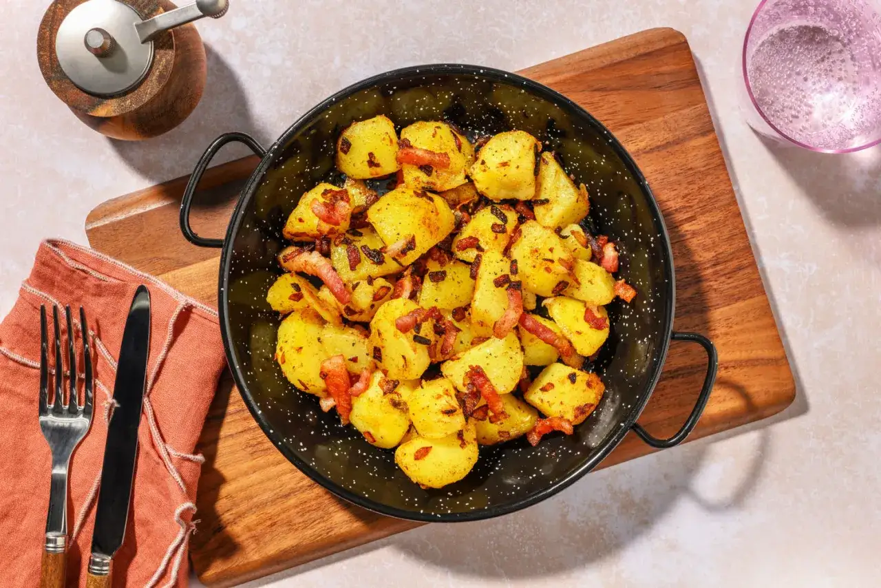 Patate in tecia dorate e croccanti, condite con pancetta affumicata. Un contorno saporito pronto per essere gustato.