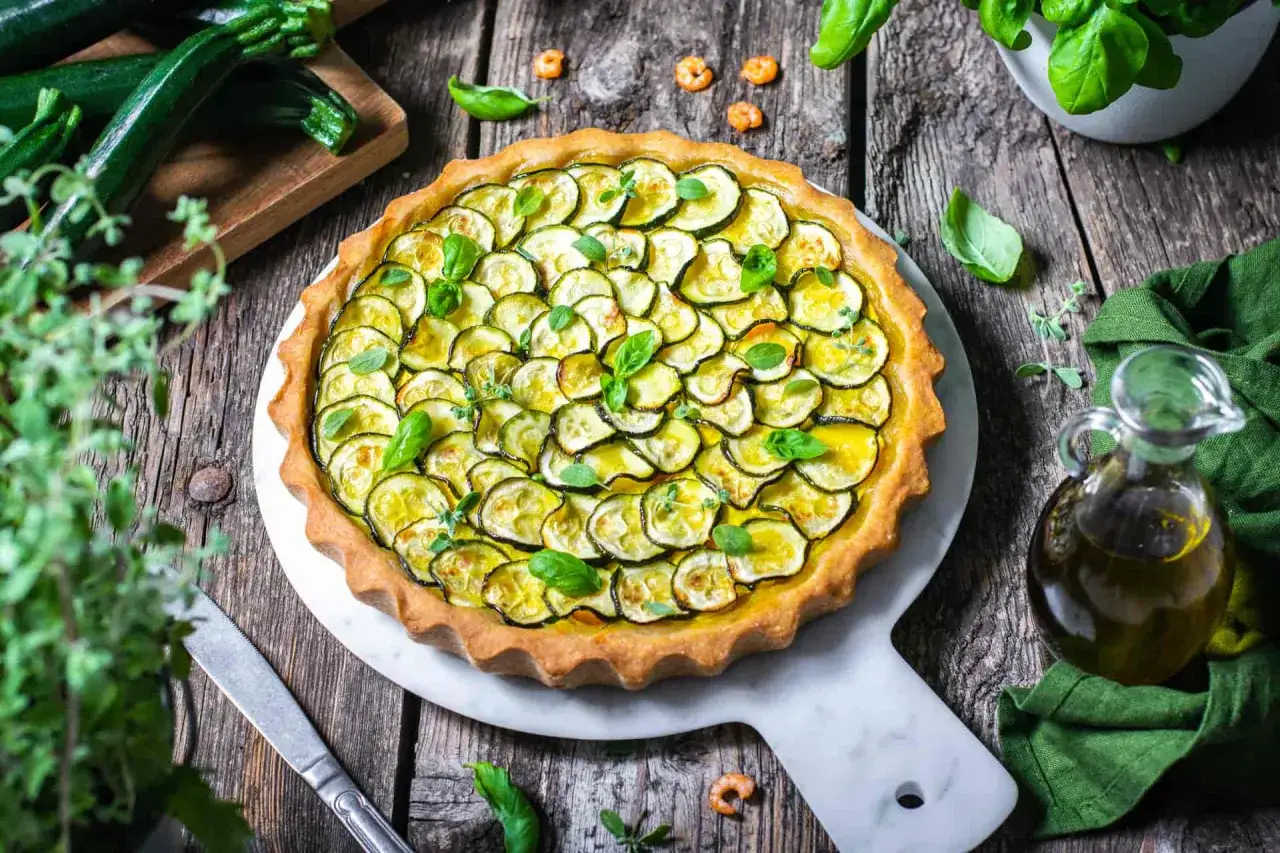 Deliziosa crostata salata con zucchine fresche e basilico, pronta per essere gustata.