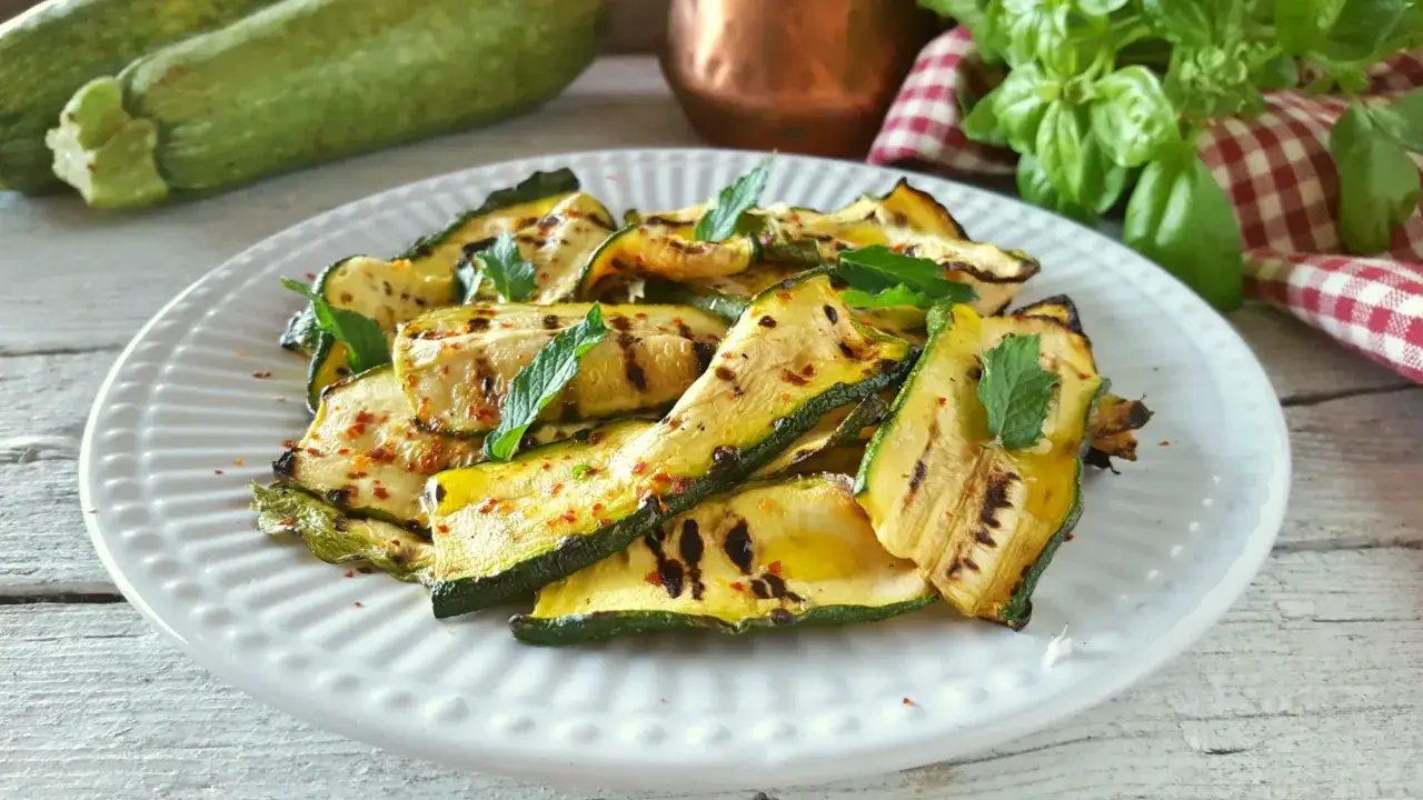 Zucchine grigliate condite con peperoncino e menta fresca, un contorno estivo leggero e saporito.