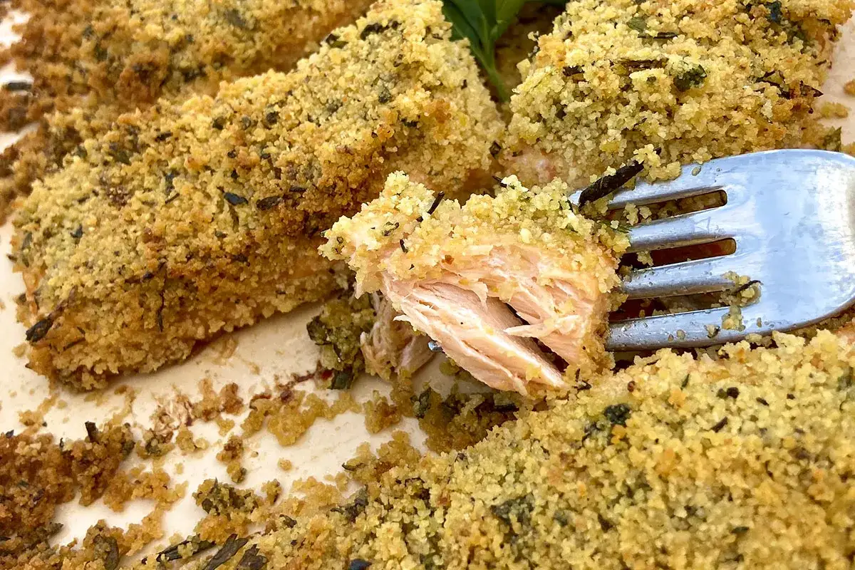 Salmone al forno con crosta croccante di pangrattato ed erbe aromatiche. Un boccone invitante pronto per essere gustato.