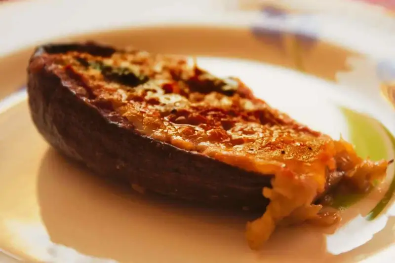 Melanzane ripiene calabresi, un piatto saporito con un ripieno dorato e filante, pronto per essere gustato.