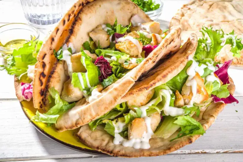 Pita ripiena di pollo e insalata fresca, condita con una cremosa salsa yogurt.